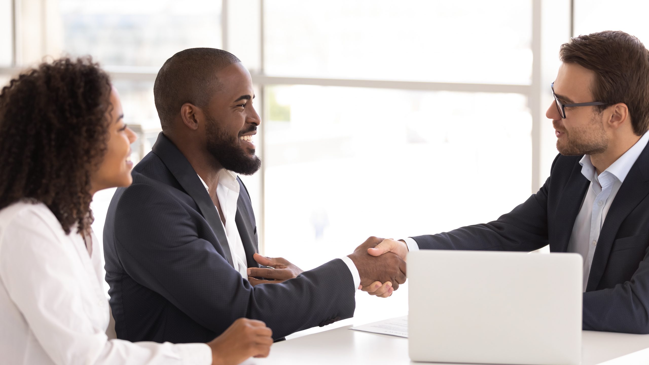 Happy couple shake hand of real estate agent