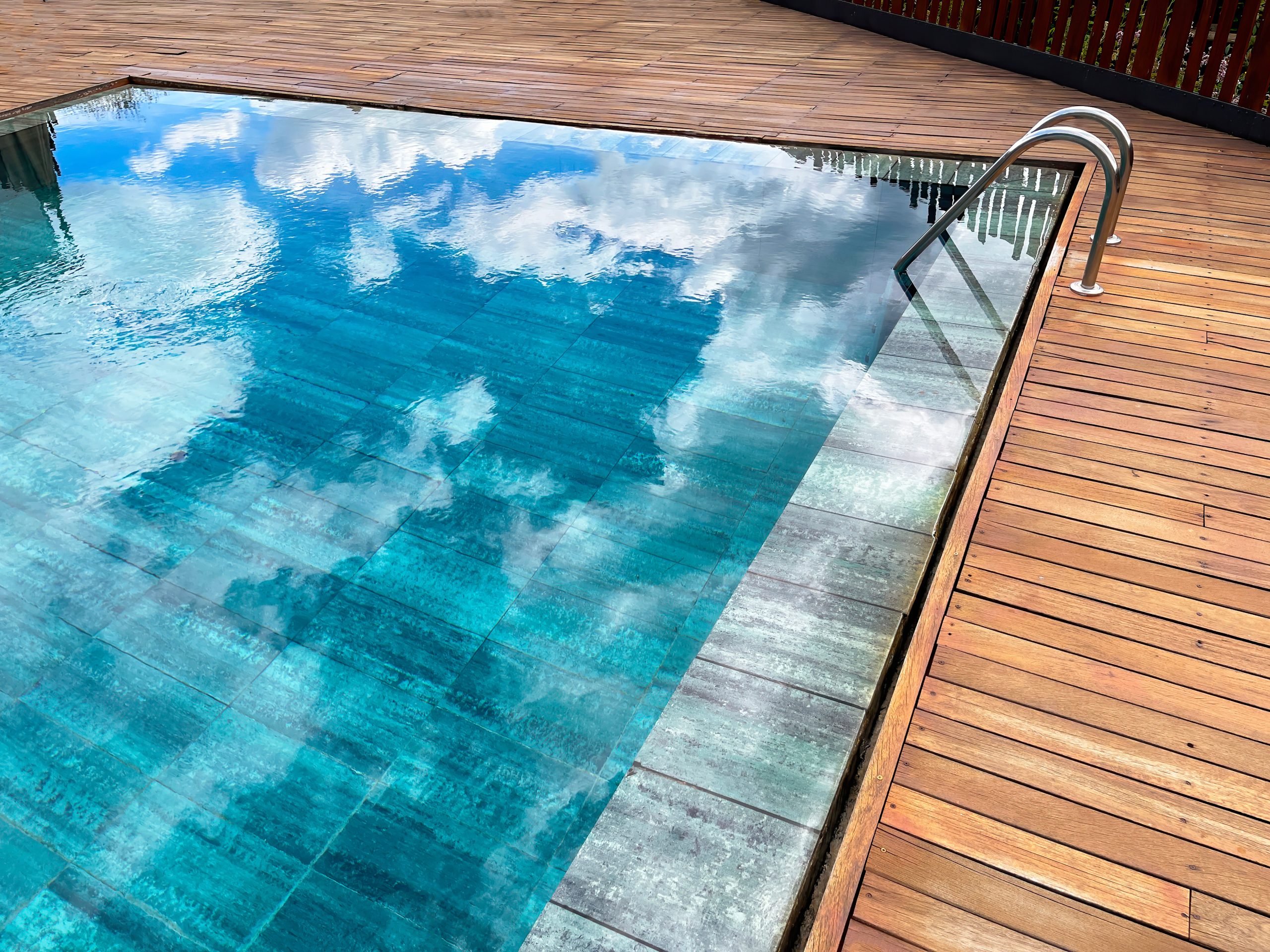 2023 pool trends - rimless pool with teak wood deck surrounding
