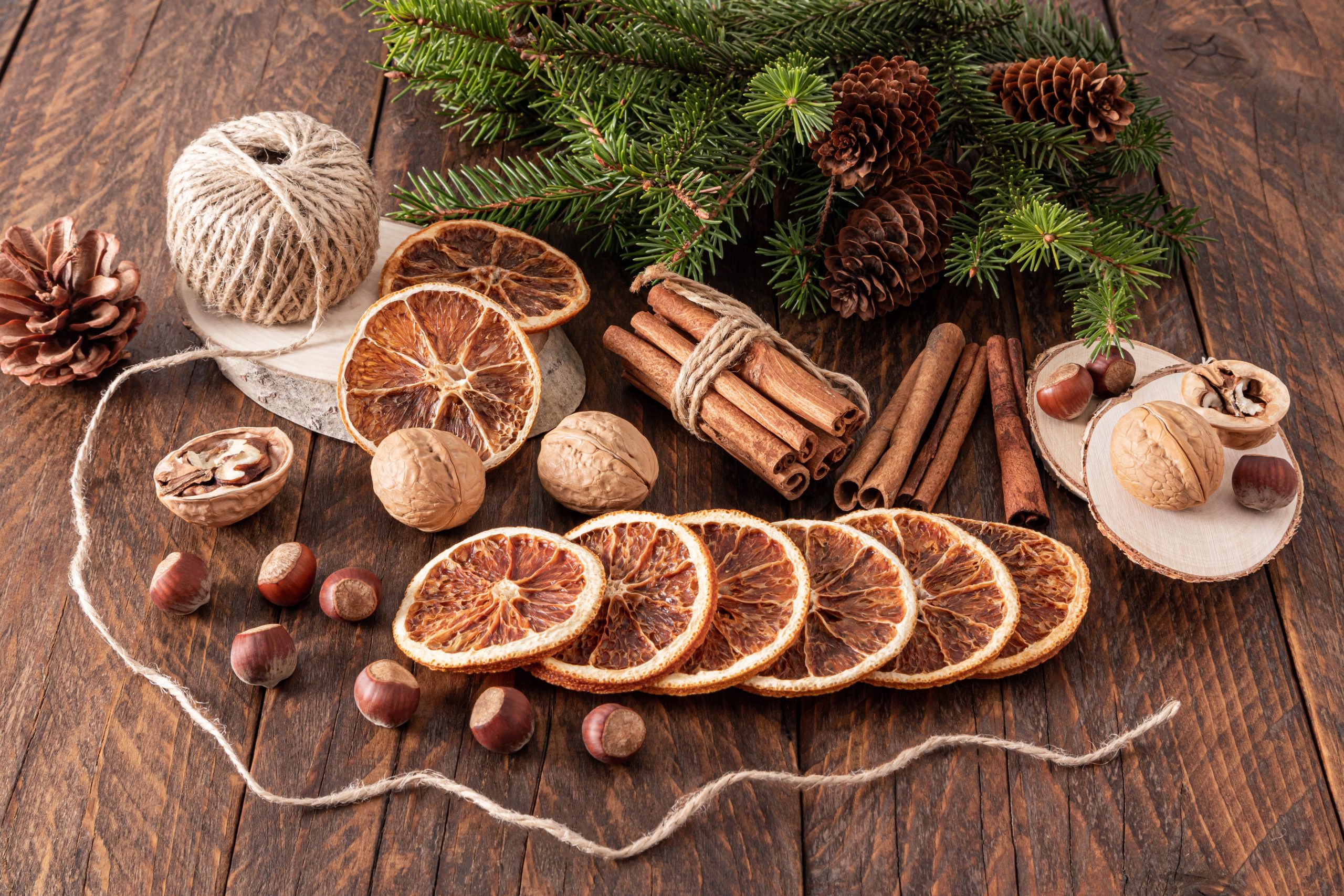 Christmas handmade natural decorations. Garland made of dried slices of oranges on wooden table. Winter still life composition