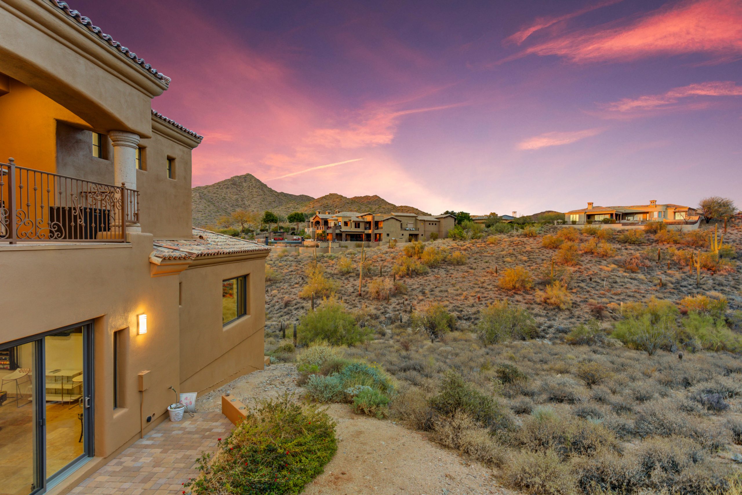 image of a tan home in the desert with a sunset sky