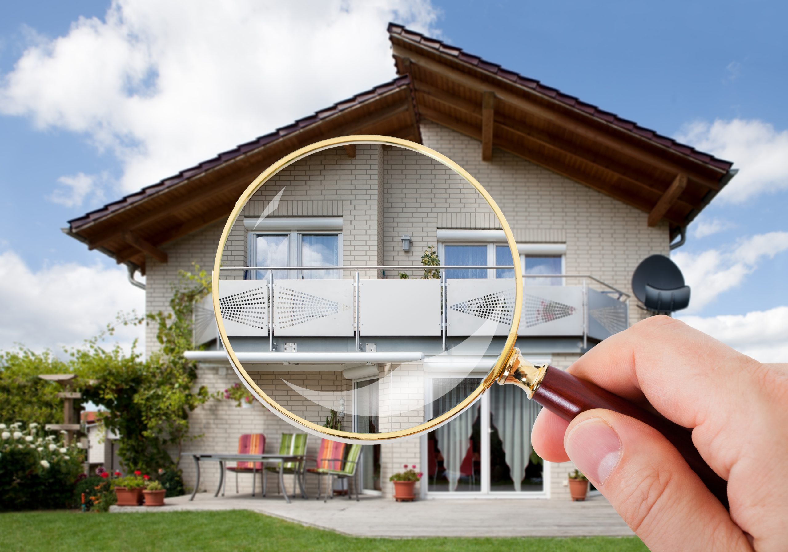 image of a home inspector pro looking at a residential home through a magnifying glass