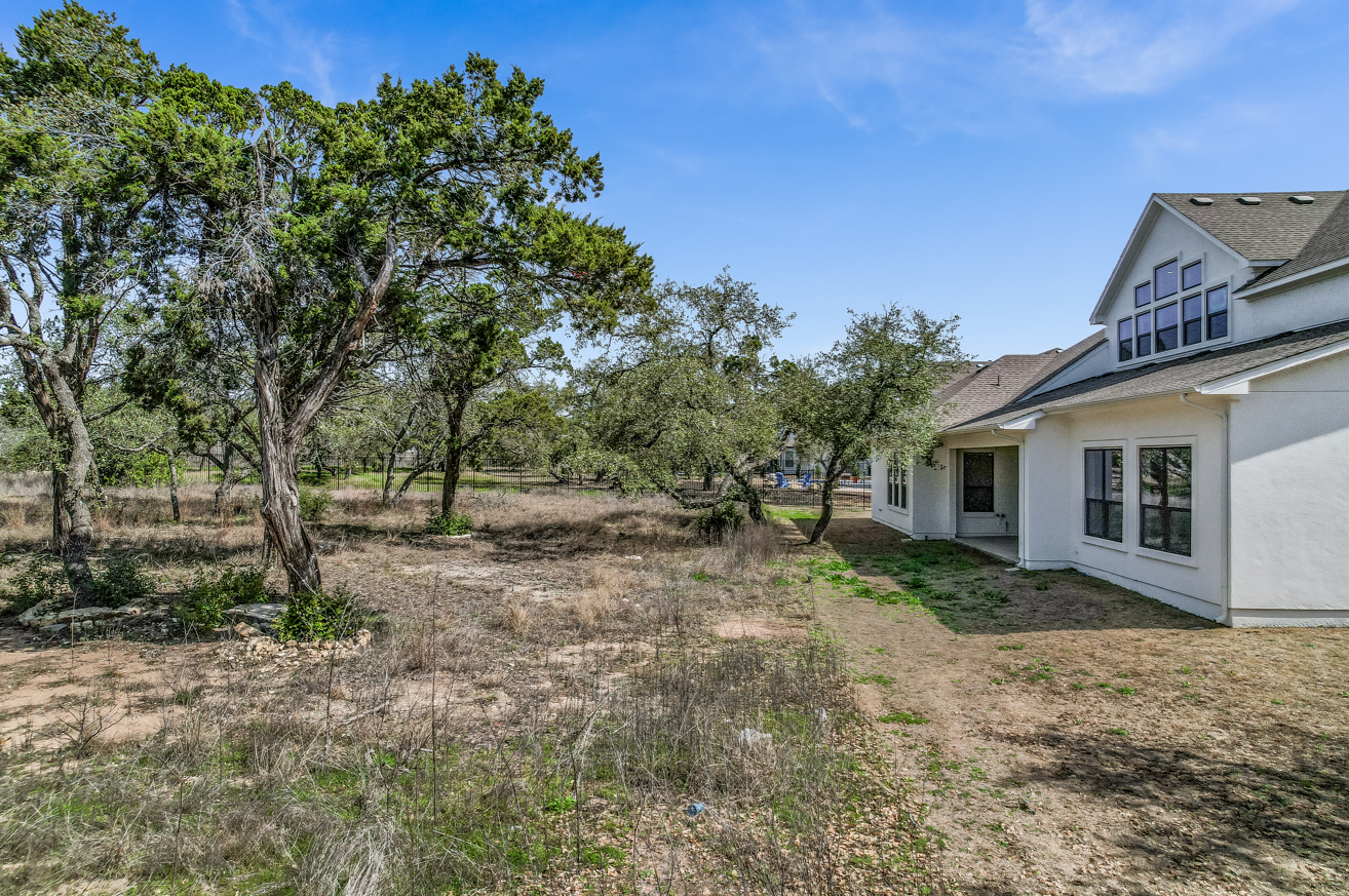 Before image of property with backyard and trees, empty lawn