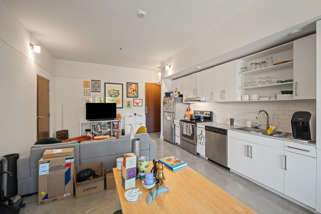 residential living room / kitchen space with clutter